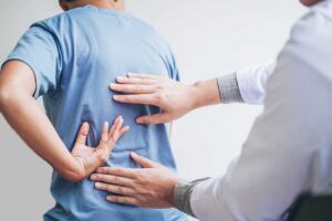 A chiropractor gently performing a spinal adjustment on a patient in a calm clinical setting.